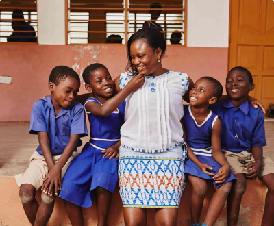 Teacher sitting with school children 