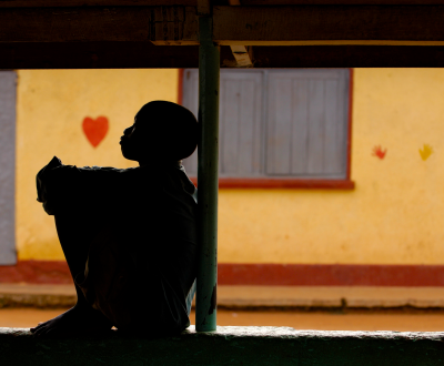 A boy sitting beside a pillar