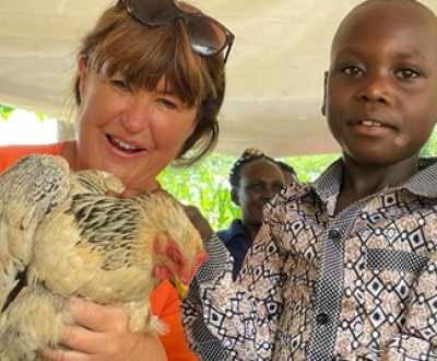 A women and a boy with a chicken.