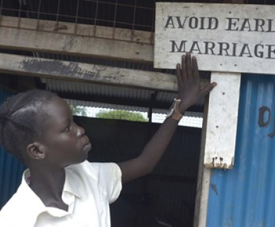 A girl looking to a board says, avoid early marriage