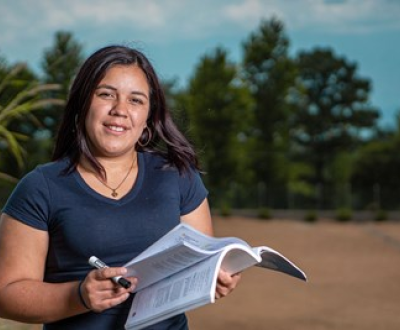 Young female teacher from Honduras flicking through a book