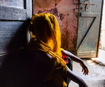 Girl siiting in her house looking outside