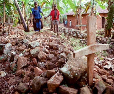 People walk around graves near their house