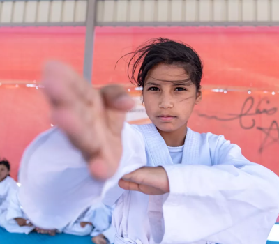 A Syrian girl shows her technique to the camera as she takes part in a karate class in Jordan's Azraq refugee camp