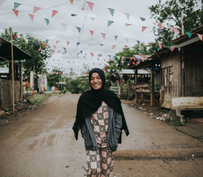 Woman standing in the middle of the road in a village