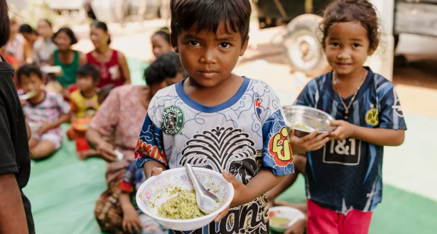 Children holding plates with food on their hands