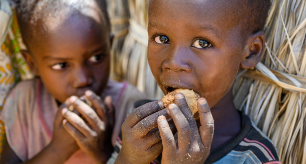 Two Childrens are eating some nuts.