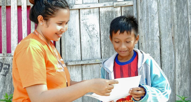 Jackly from Indonesia is reading a letter from his sponsor.