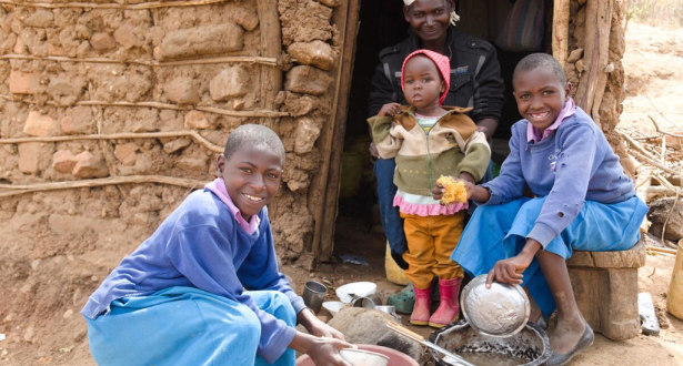 Anastacia from Kenya and her daughters wash dishes after eating a small ration of maize.