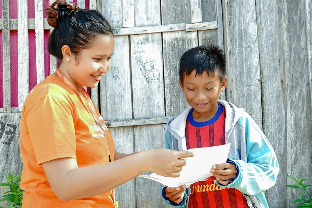 Jackly from Indonesia is reading a letter from his sponsor.