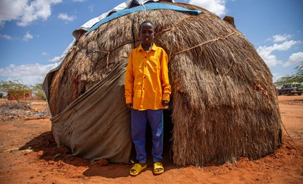 BOy standing outside his hut