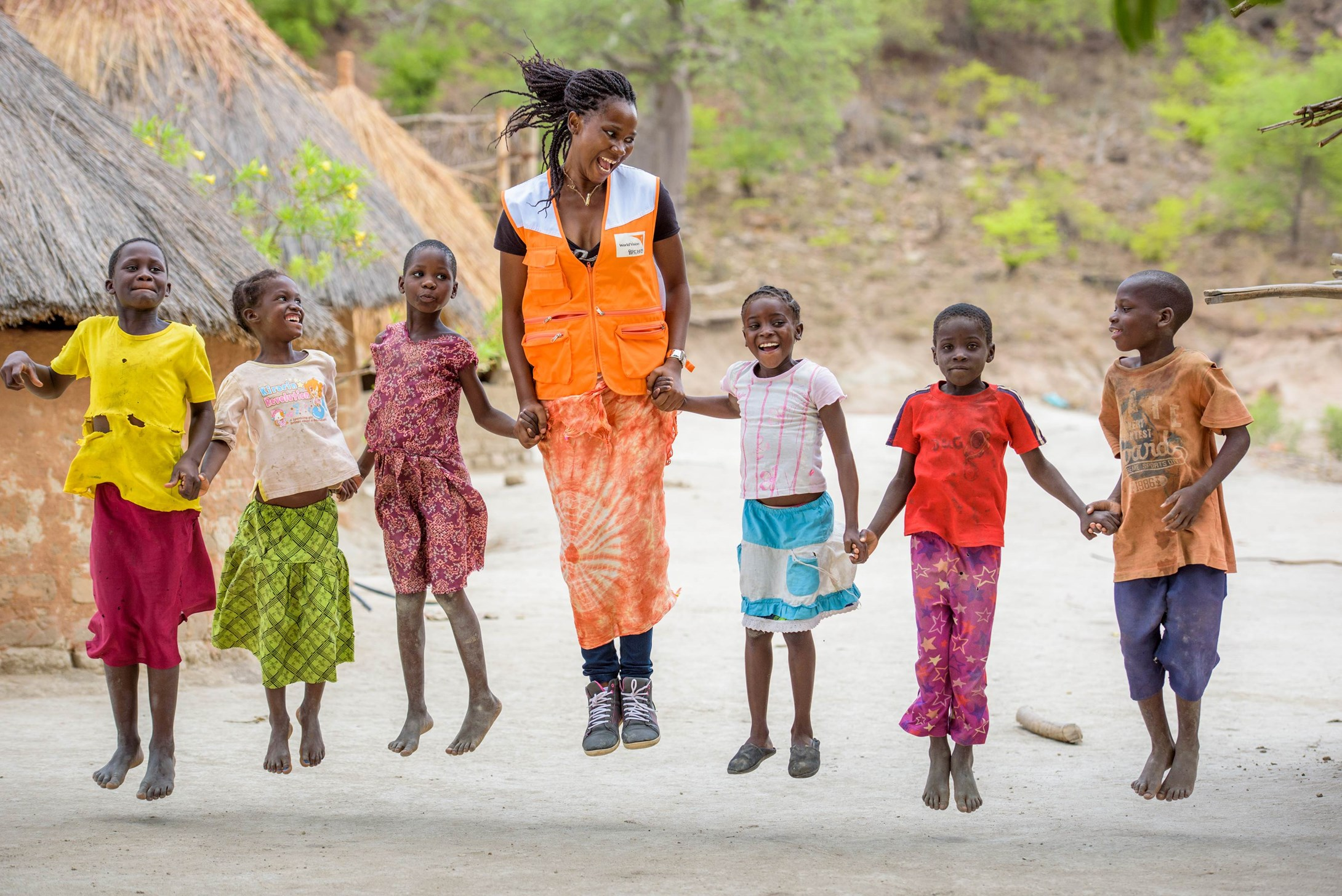 World Vision staff member Florence Mulenga jumps with children in Zambia